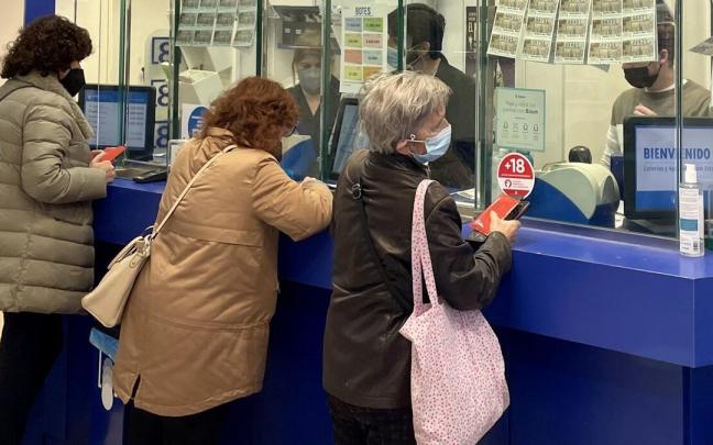 Varias personas comprando lotería de Navidad en la administración de la calle Narrica de Donostia, que ha vendido el quinto premio