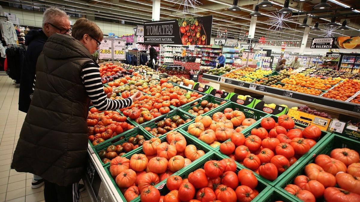 Dos ciudadanos revisan tomates en un supermercado