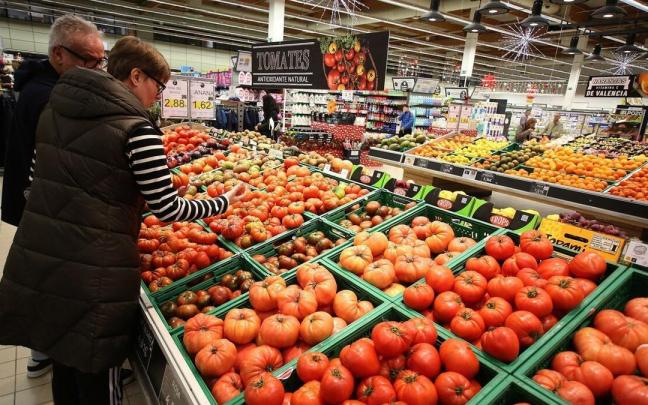 Dos ciudadanos revisan tomates en un supermercado Dos ciudadanos revisan tomates en un supermercado