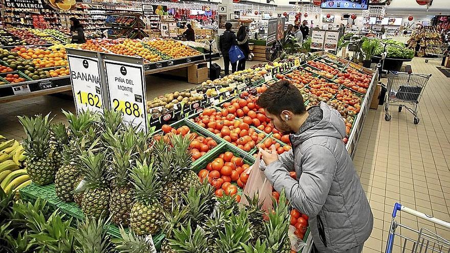 Un hombre compra fruta en un supermercado.