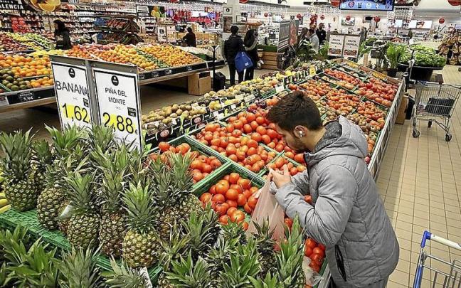 Un hombre compra fruta en un supermercado.