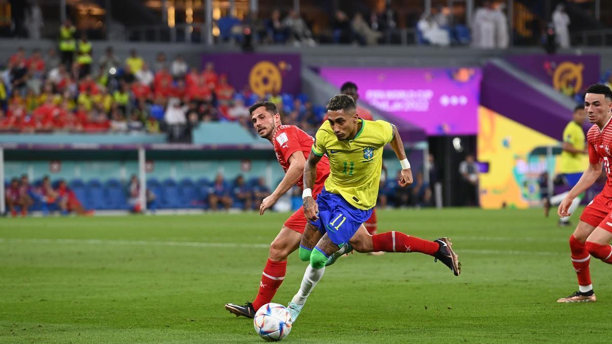 Raphinha protege el balón de Remo Freuler.