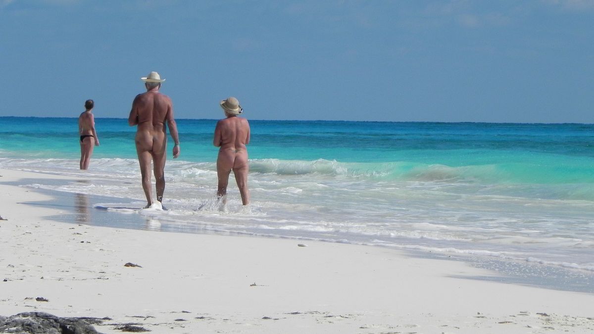 Una pareja practica el nudismo en la playa.