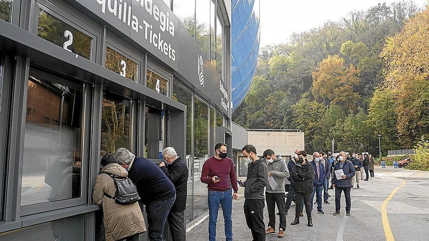 Varias personas hacen cola frente a la taquilla del estadio de Anoeta.