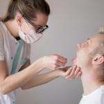 Una médico examina la boca de un paciente