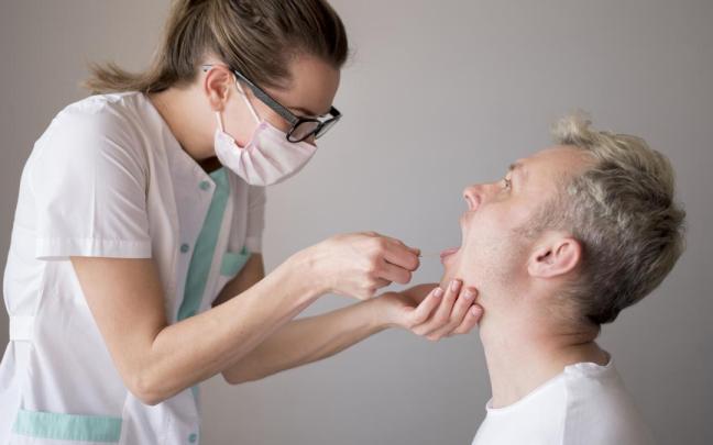 Una médico examina la boca de un paciente Una médico examina la boca de un paciente