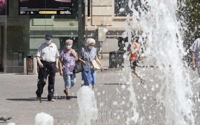 Personas mayores junto a una fuente en Teruel