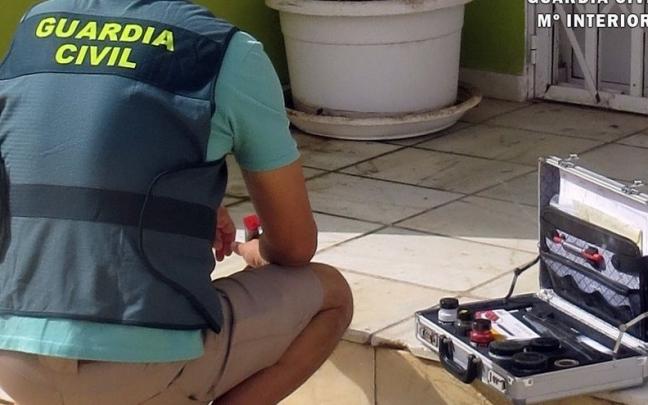 Un agente de Guardia Civil recoge vestigios del apuñalamiento de un hombre a las puertas de un club cannábico de Almería. Un agente de Guardia Civil recoge vestigios del apuñalamiento de un hombre a las puertas de un club cannábico de Almería.