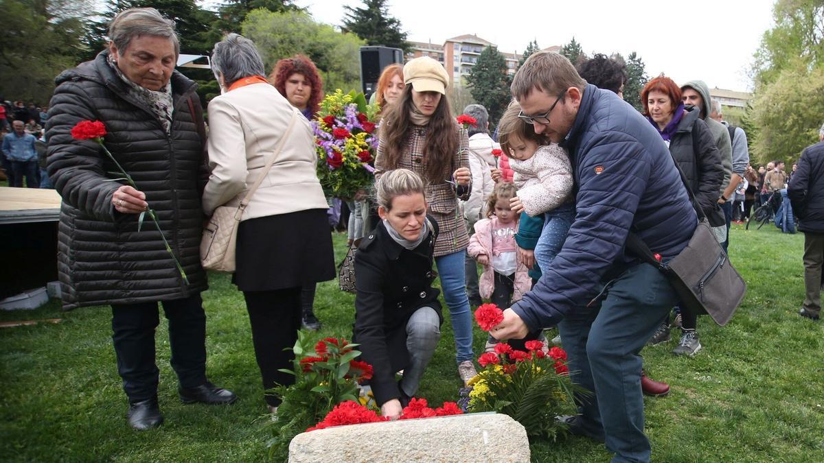 Varias personas depositan flores en la Vuelta del Castillo.