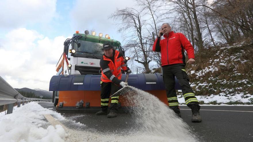 Una máquina quitanieves y dos operarios trabajando en el alto de Urkiola para despejar la carretera foral.