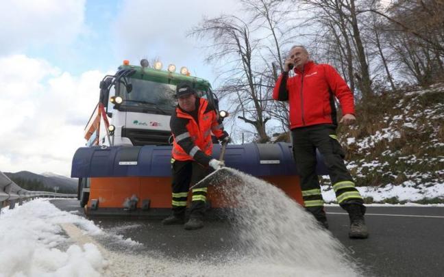 Una máquina quitanieves y dos operarios trabajando en el alto de Urkiola para despejar la carretera foral.