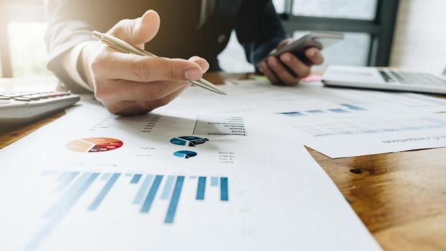 Un trabajador realiza cuentas con su móvil.