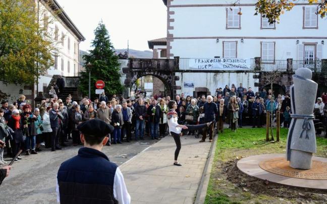 Oihana Santxotena, de Baztandarra dantza taldea, bailando el aurresku, delante de la escultura de Mikel Iriarte, y rodeada de la gente que asistió al homenaje. Oihana Santxotena, de Baztandarra dantza taldea, bailando el aurresku, delante de la escultura de Mikel Iriarte, y rodeada de la gente que asistió al homenaje.