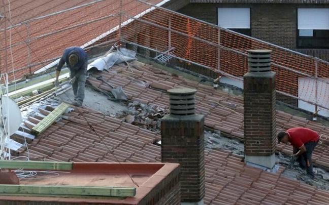 Dos obreros trabajan en la construcción de un edificio de viviendas. Dos obreros trabajan en la construcción de un edificio de viviendas.