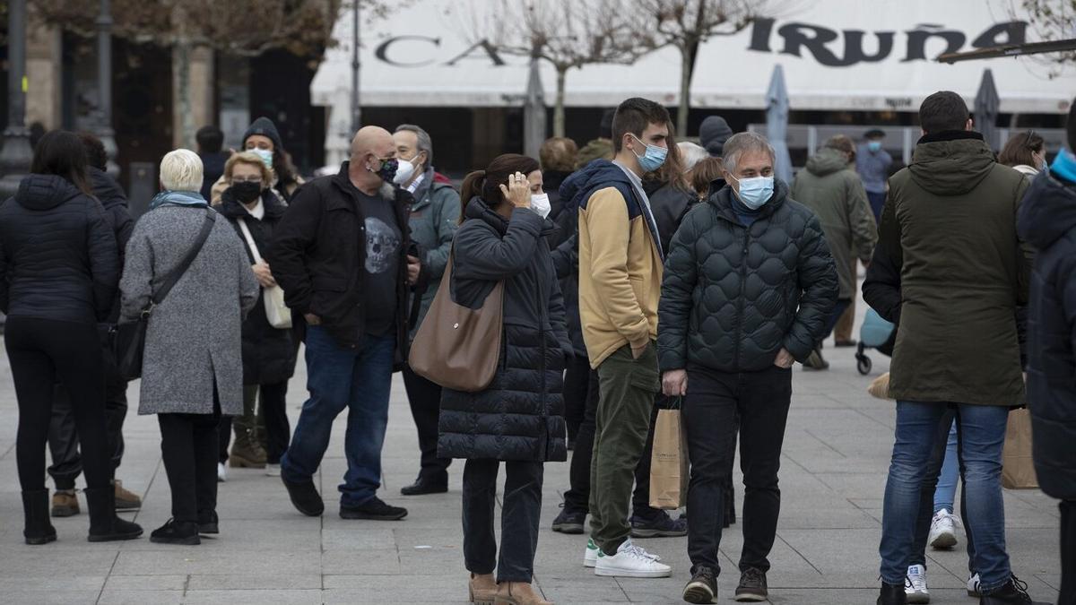 Decenas de personas caminan por la plaza del Castillo con mascarilla durante la Navidad de 2021.