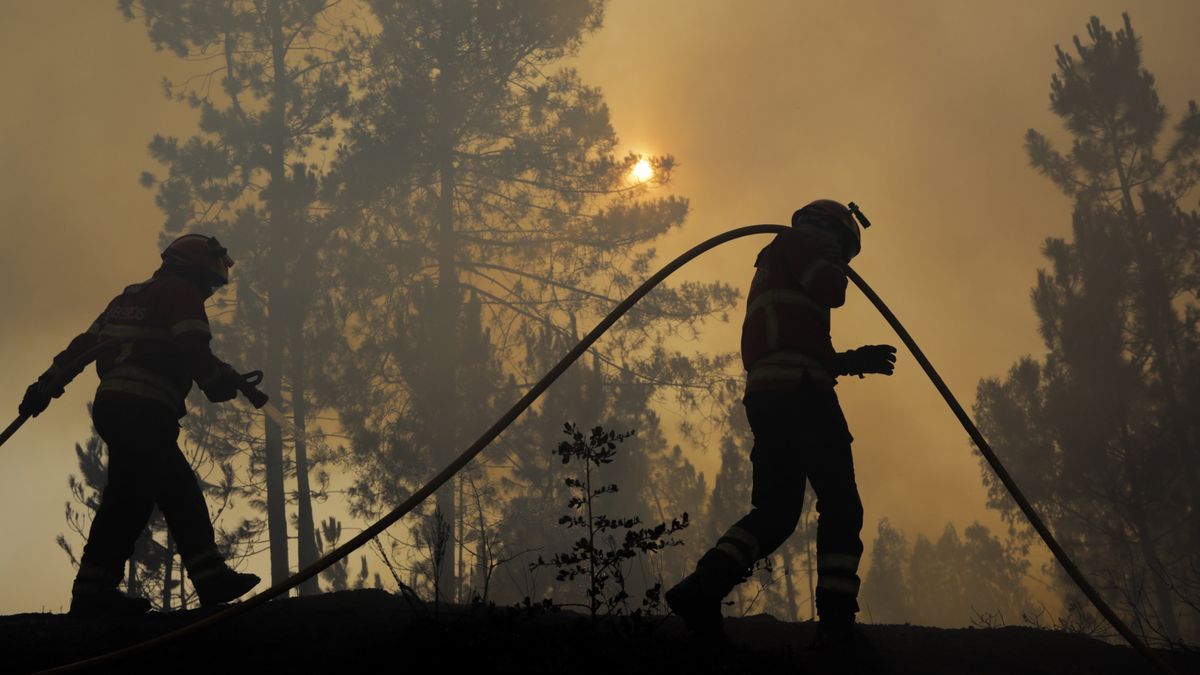 Dos bomberos luchan contra las llamas en Cruzinha.