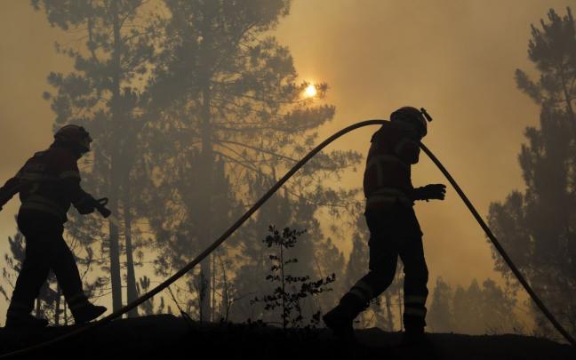 Dos bomberos luchan contra las llamas en Cruzinha.