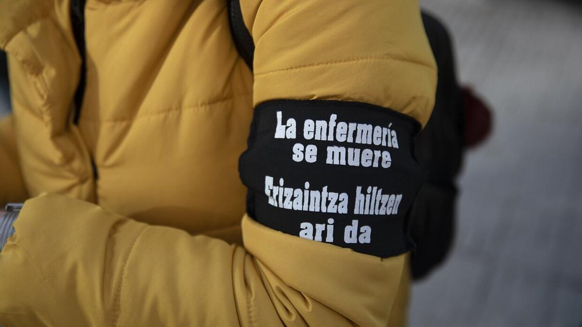 Participante en una concentración convocada por SATSE con un brazalete con el eslógan "La enfermería se muere"