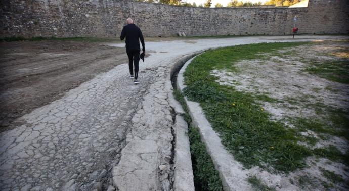 Una persona camina al lado de la acequia destrozada