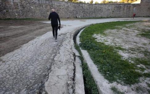 Una persona camina al lado de la acequia destrozada Una persona camina al lado de la acequia destrozada