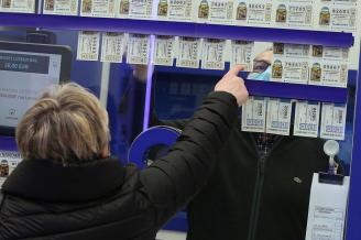 Una mujer elige un número de Lotería en una administración.
