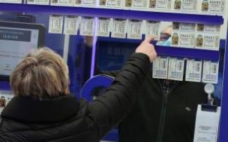 Una mujer elige un número de Lotería en una administración. Una mujer elige un número de Lotería en una administración.