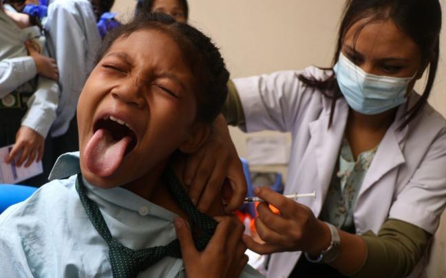 Una menor recibe una vacuna covid en Nepal.