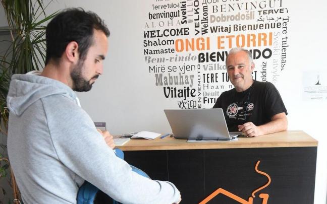 Iñaki Reino, gerente del hostal All Iron, atiende a un huésped en la recepción Iñaki Reino, gerente del hostal All Iron, atiende a un huésped en la recepción