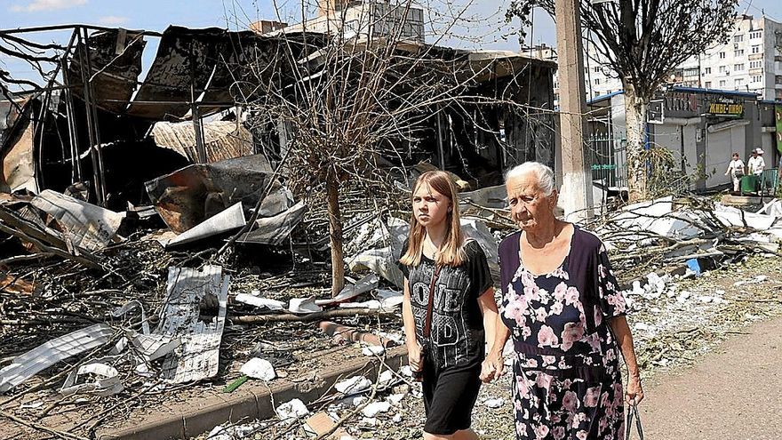 Una abuela y su nieta caminan entre los destrozos de un mercado local en Bakhmut, en Donetsk.