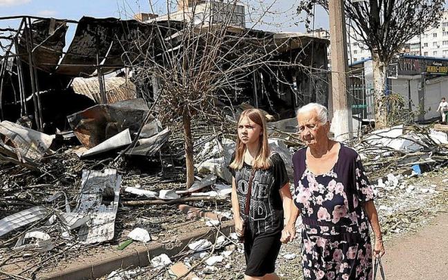 Una abuela y su nieta caminan entre los destrozos de un mercado local en Bakhmut, en Donetsk.