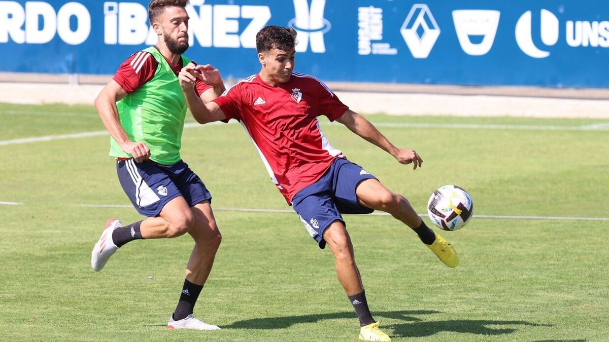 Manu Sánchez despeja un balón ante la presión de Roberto Torres este martes en Tajonar.
