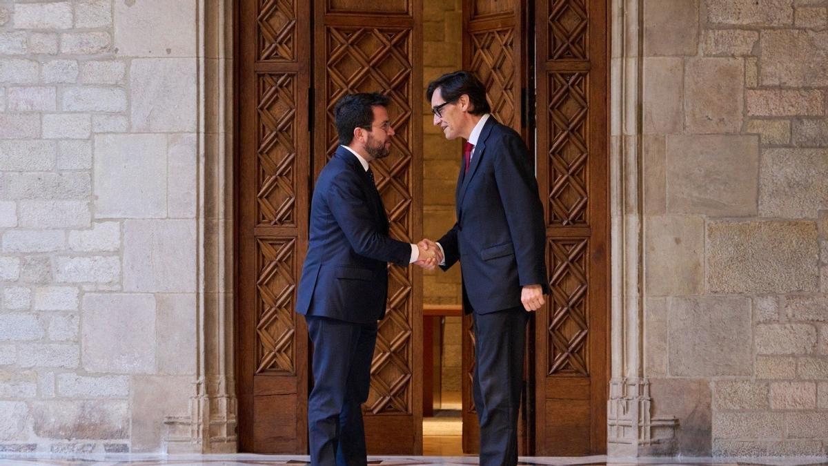 Pere Aragonès y Salvador Illa se saludan antes de firmar el acuerdo de Presupuestos catalanes.