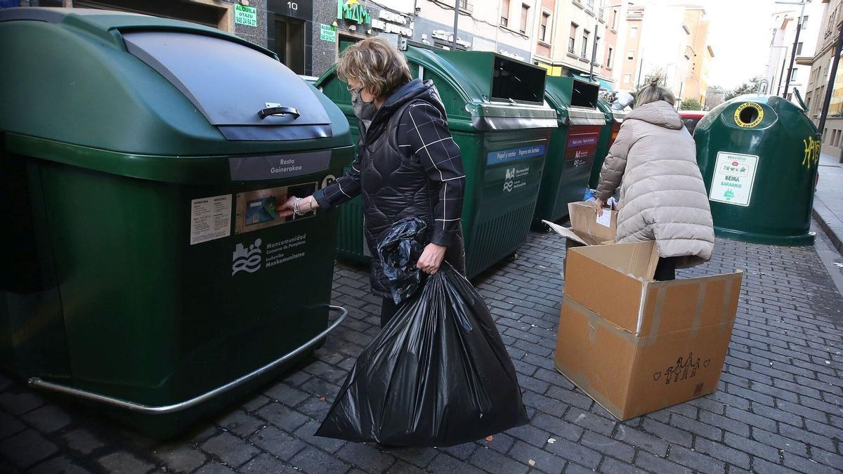 Personas haciendo uso de los contenedores de Pamplona.