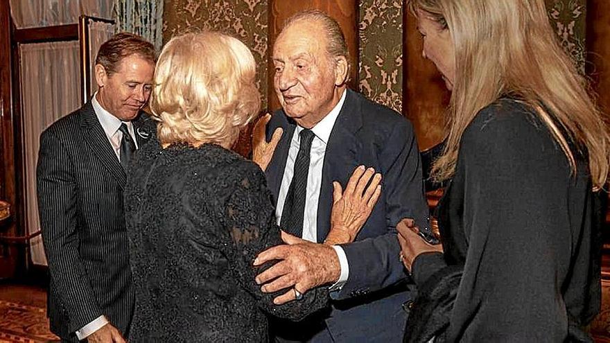 El emérito Juan Carlos I, saludando a la reina consorte británica.