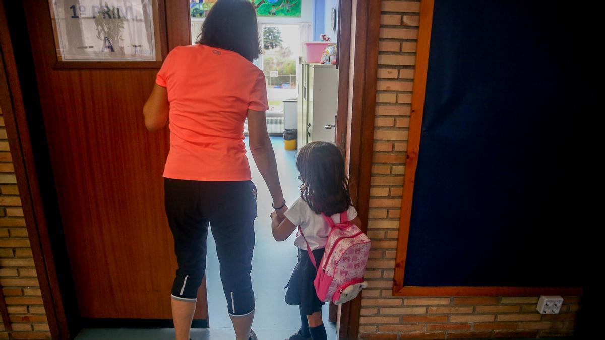 Una profesora acompaña a una alumna en el primer día de clase.