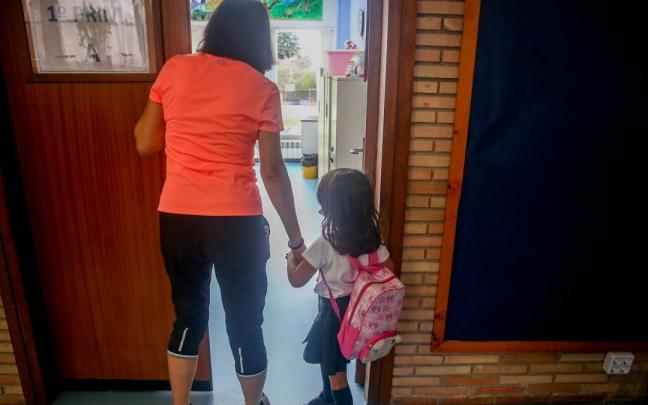 Una profesora acompaña a una alumna en el primer día de clase. Una profesora acompaña a una alumna en el primer día de clase.