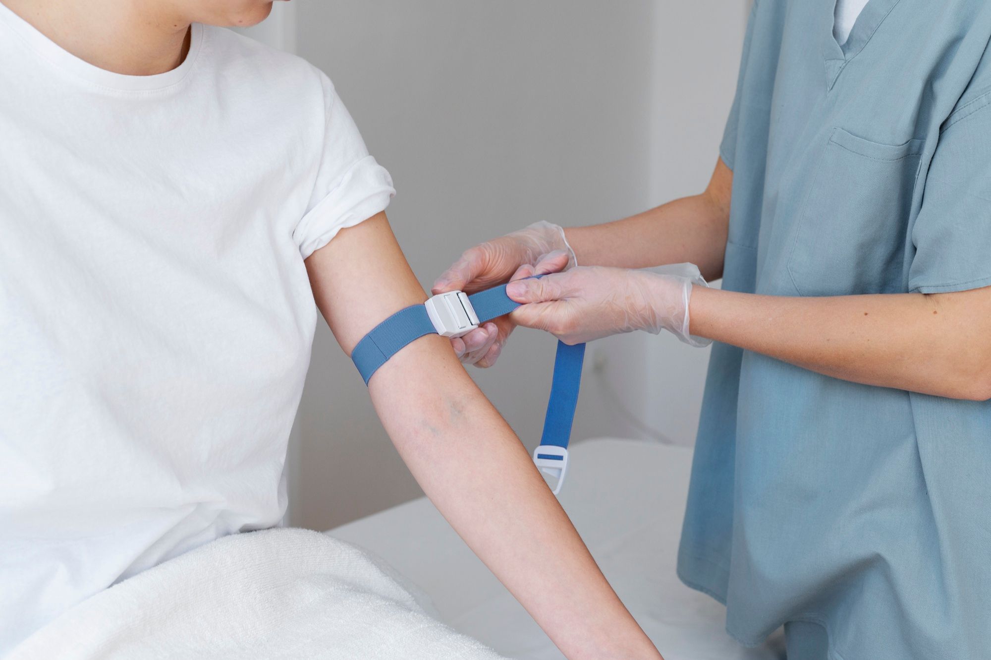 Una enfermera coloca la goma en el brazo antes de extraer la sangre.