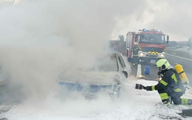 Un bombero trabaja en la extinción del incendio del vehículo Un bombero trabaja en la extinción del incendio del vehículo
