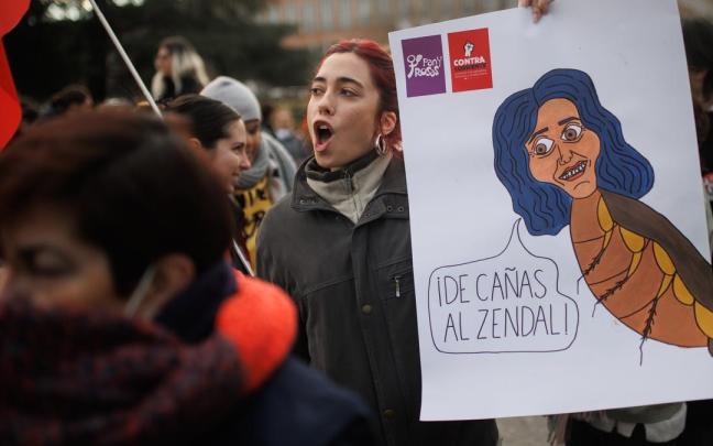 Una mujer sostiene un cartel en el que se lee 'De ca&ntilde;as al Zendal', durante la concentraci&oacute;n contra de la distinci&oacute;n de Ayuso como alumna Ilustre de la Complutense.