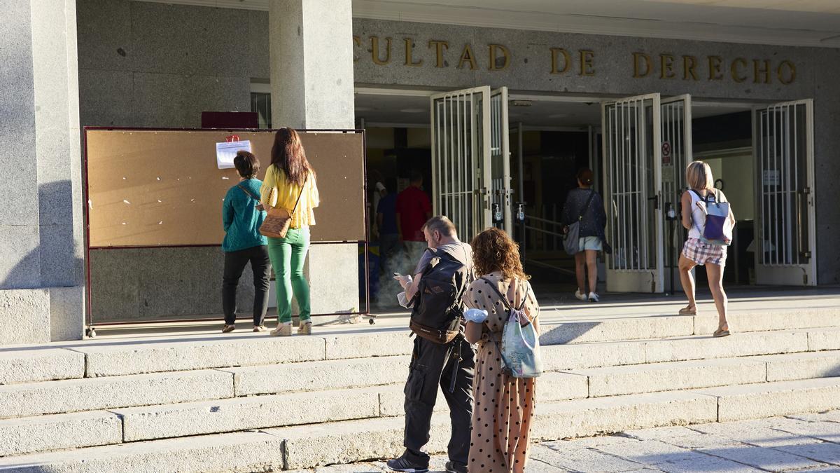 Varias personas a la entrada de la Facultad de Derecho de la Universidad Complutense de Madrid.