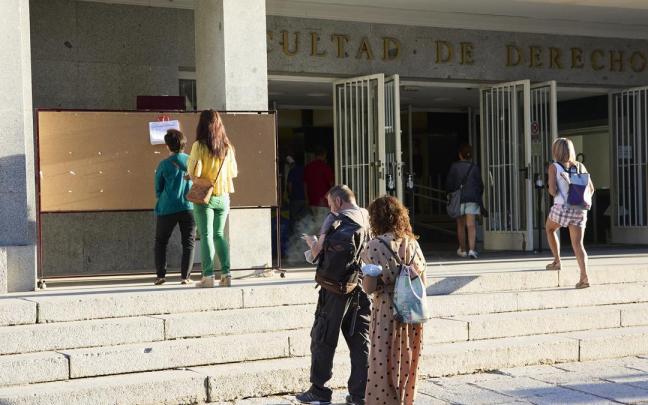 Varias personas a la entrada de la Facultad de Derecho de la Universidad Complutense de Madrid.