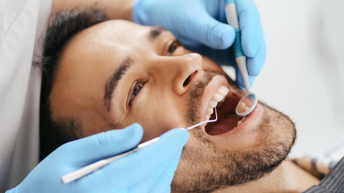 Un dentista realiza la revisión anual a un paciente.