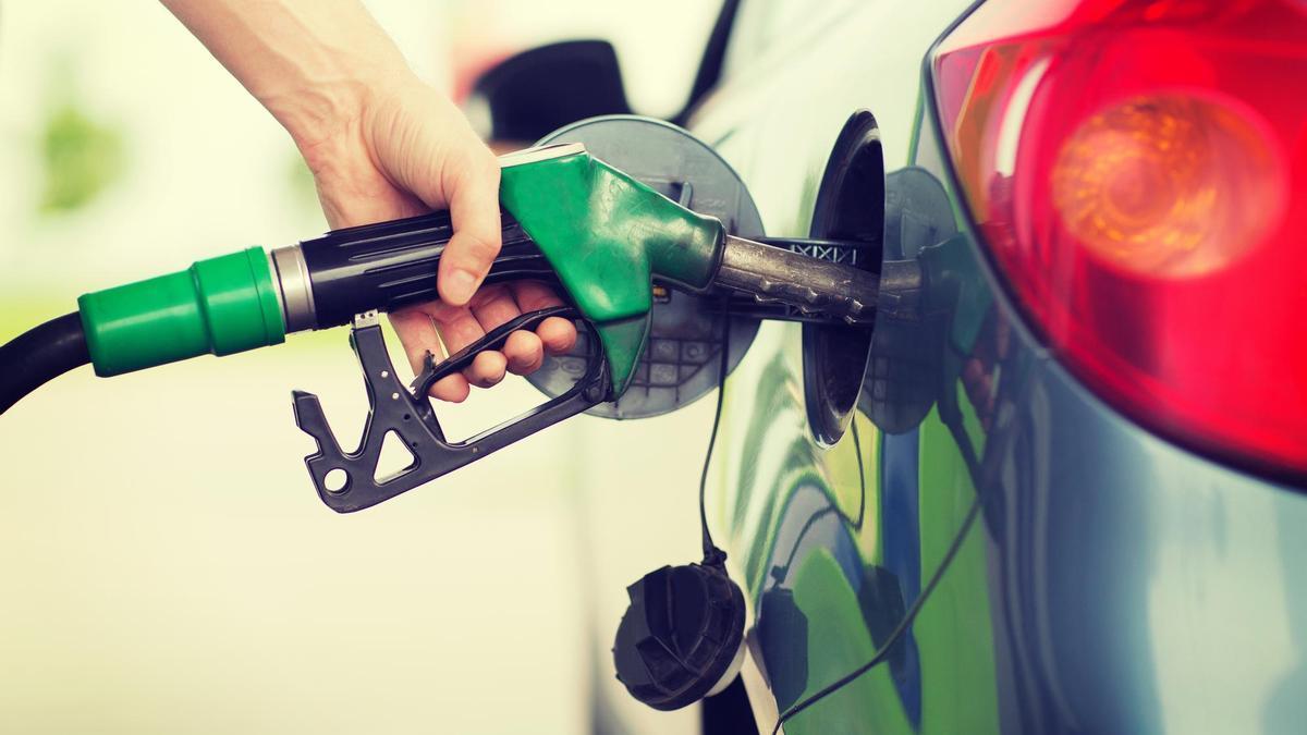 Una persona reposta combustible en su vehículo.
