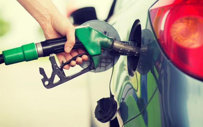 Una persona reposta combustible en su vehículo.