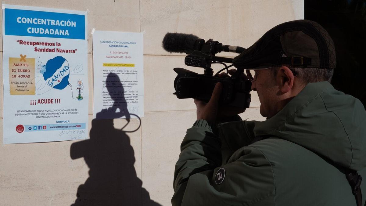 Un cámara graba un cartel colocado en el edificio de consultas externas el primer día de huelga.