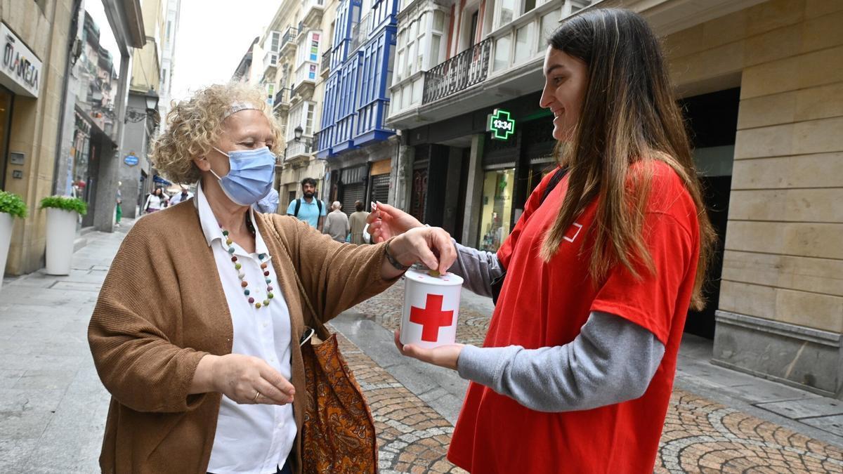 Una mujer realiza su donativo a la Cruz Roja.