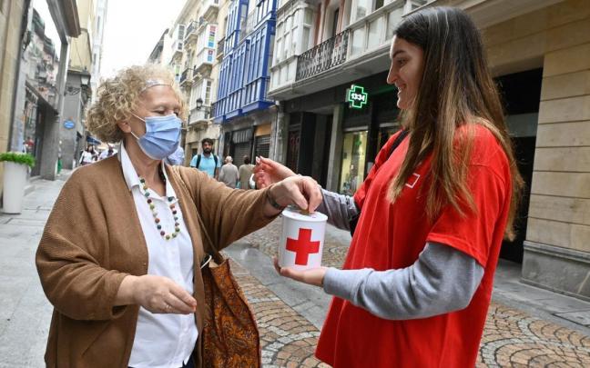 Una mujer realiza su donativo a la Cruz Roja.