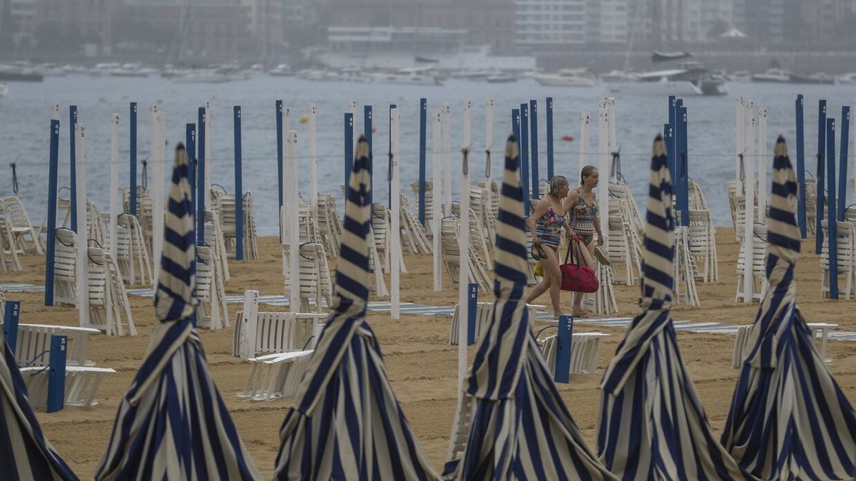 Dos mujeres en la playa donostiarra de Ondarreta en una tarde de tormenta