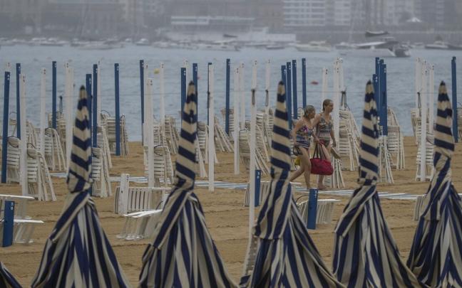 Dos mujeres en la playa donostiarra de Ondarreta en una tarde de tormenta