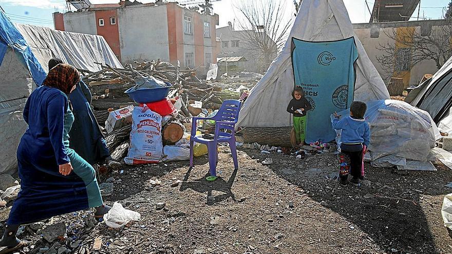 Una familia monta una tienda de campaña entre los restos de su casa en la localidad turca de Adiyamán. | FOTO: EFE